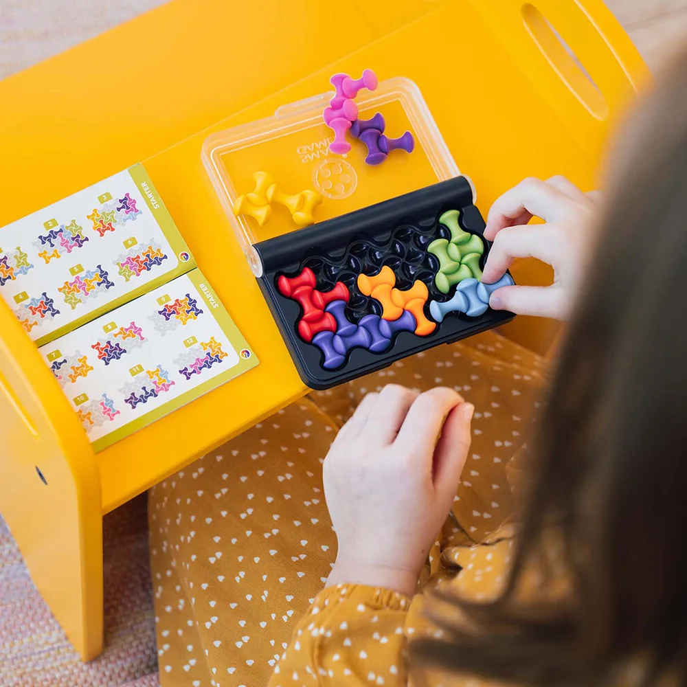 Manufacturer play scene showing the board, partly placed pieces and challenge booklet.