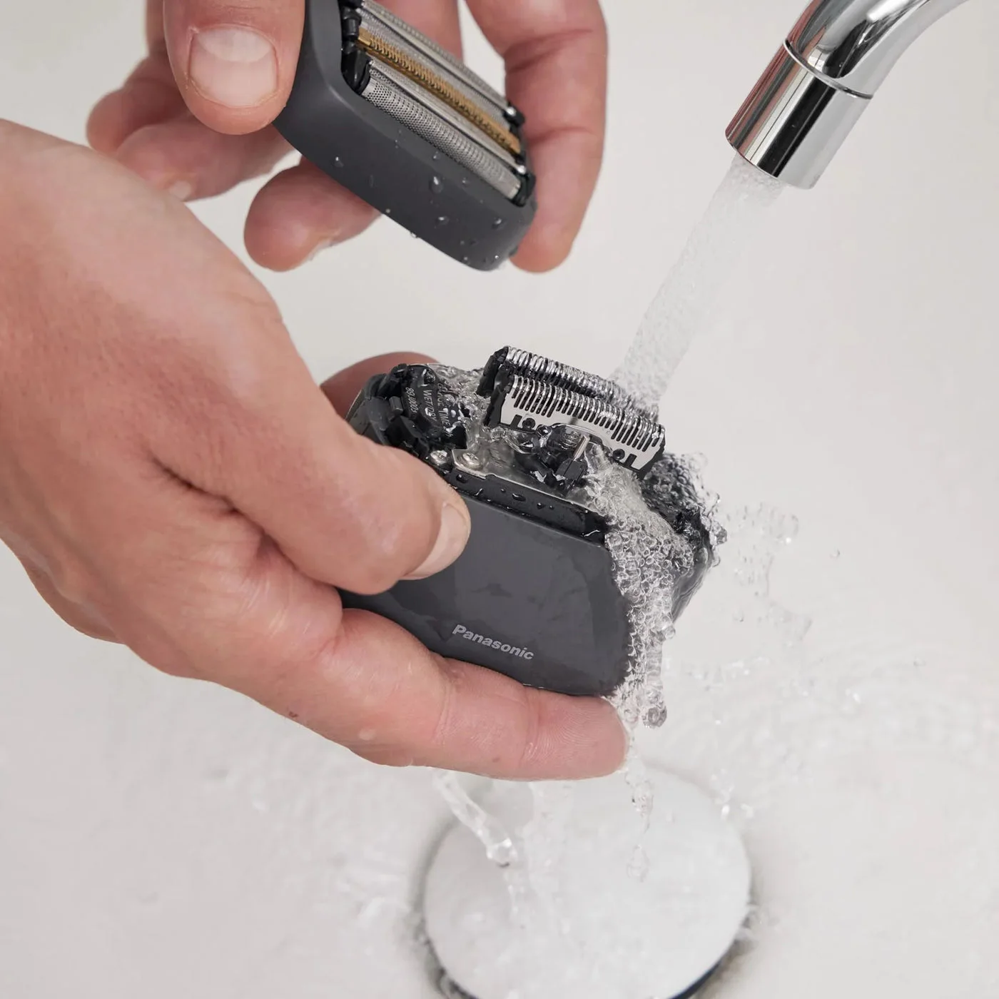 Rinsing the detachable head in a manufacturer cleaning reference.
