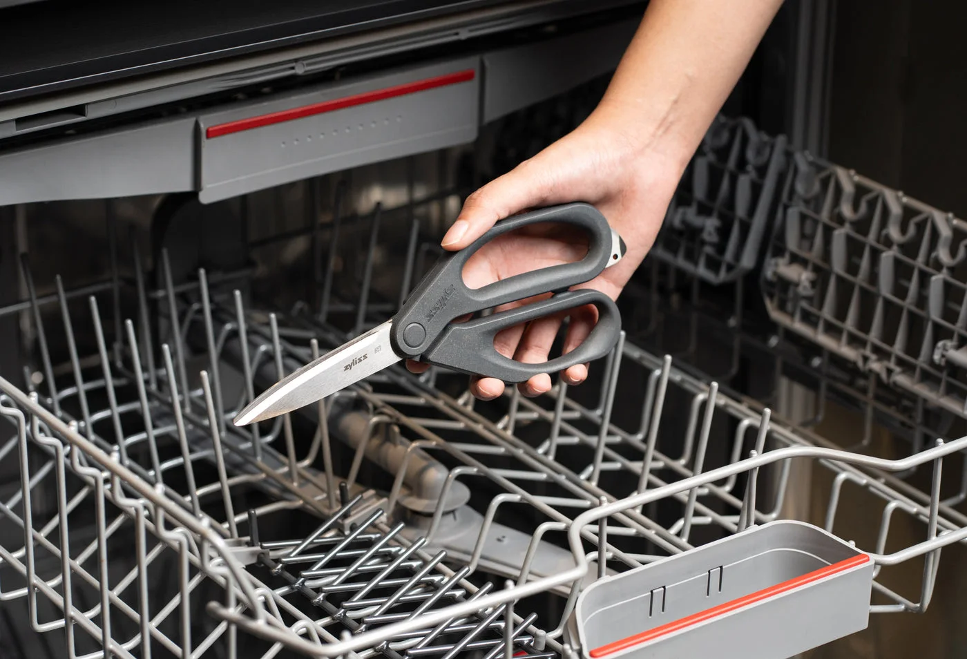 Scissors loaded into a dishwasher; follow supplied care instructions.