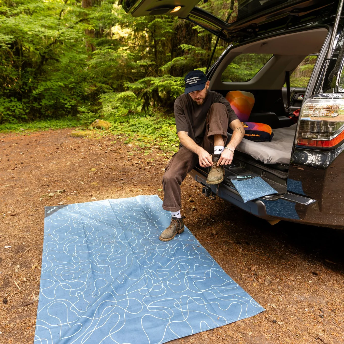 Large mat as a ground cover beside a vehicle.