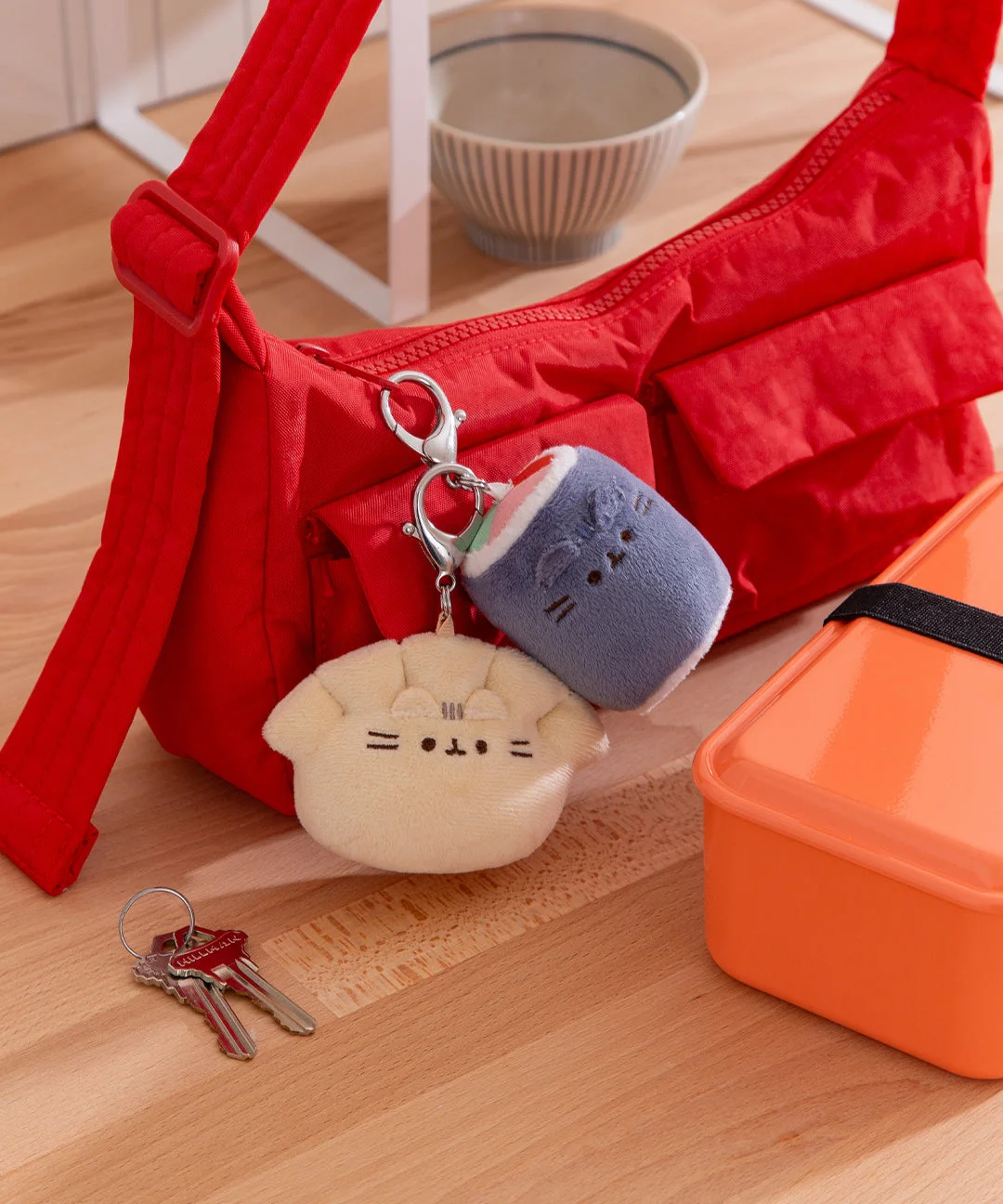two charms on red bag; bag excluded and one plush per box